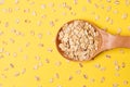 Oat flakes. Wooden spoon. Yellow bright background. Healthy eating