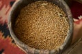 Oat grains in wooden barrel, close-up. Barley beans bowl. Malt or wheat Grains.