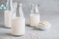 Oat Milk in glass. Vegan non dairy oat milk on gray stone background