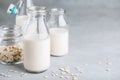 Oat Milk in glass. Vegan non dairy oat milk on gray stone background