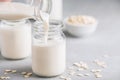 Oat Milk in glass. Vegan non dairy oat milk on gray stone background