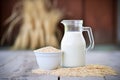 oat milk in rustic jug, hay bales in background Royalty Free Stock Photo
