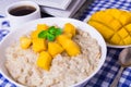 Oat porridge with fresh mango in the white bowl with coffee Royalty Free Stock Photo