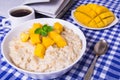 Oat porridge with fresh mango in the white bowl with coffee Royalty Free Stock Photo