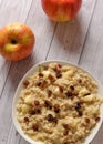 Oatmeal with apple and raisins against the background of the old tree. Muesli with an apple and raisins