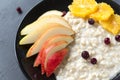 Oatmeal with berries and fruits ,porridge with pieces of pear, orange, cranberry