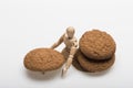 Oatmeal biscuits as tasty pastry with humanlike toy sitting nearby