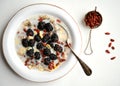 Oatmeal with blackberries and goji seeds on a white table