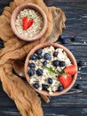 Oatmeal, blueberries, strawberries on wooden background breakfast
