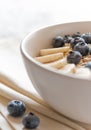 Oatmeal in bowl in close up. Healthy breakfast: Porridge oatmeal with banana, blueberry and walnuts in white bowl on linen napki