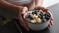 Oatmeal bowl with fruits in female hands