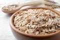 Oatmeal, bowl and spoon on white table, closeup