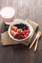 Oatmeal in bowl topped with fresh blueberries, cranberries, strawberries, raspberries, blackberries and berry smoothie Royalty Free Stock Photo