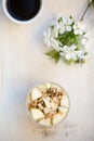 Oatmeal breakfast flavoured with mashed banana, topped with sliced pear, walnuts, sliced almonds and honey, view from