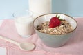 Oatmeal breakfast, muesli in ceramic bowl with strawberries. Glass of milk. Healthy food. Close up