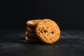 Oatmeal cookies with chocolate on a black background with sunlight. Oatmeal chocolate chip cookies. Royalty Free Stock Photo