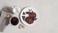 Oatmeal cookies with cocoa and chocolate on a white plate, cup of coffee and a milk jug Royalty Free Stock Photo