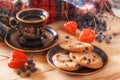 Oatmeal cookies and coffee on a wooden table with physalis and forest berries on the background of a warm scarf