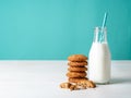Oatmeal cookies with flax seeds and milk in bottle, healthy snack. Light background, bright blue wall Royalty Free Stock Photo