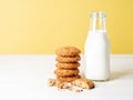 Oatmeal cookies with flax seeds and milk in bottle, healthy snack. Light background, bright yellow wall Royalty Free Stock Photo