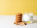 Oatmeal cookies with flax seeds and milk in a glass, healthy snack. Light background, bright yellow wall Royalty Free Stock Photo