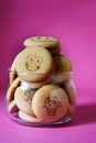 Oatmeal cookies in the form of an emoticon on a pink background. Shortbread cookie for breakfast. Baby biscuits for snacks