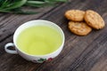 Oatmeal cookies and mug of aromatic green tea. Vintage wooden background