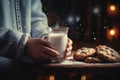 Oatmeal cookies with pieces of chocolate, arranged in a stack, a child's hand holding a glass of milk on a dark