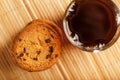 Oatmeal cookies with pieces of chocolate and a mug of coffee on a bamboo stand. Close-up Royalty Free Stock Photo