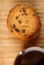 Oatmeal cookies with pieces of chocolate and a mug of coffee on a bamboo stand. Close-up Royalty Free Stock Photo