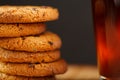 Oatmeal cookies with pieces of chocolate and a mug of coffee on a bamboo stand. Macro Royalty Free Stock Photo