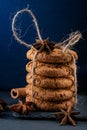 Oatmeal cookies tied with twine on a blue background with cinnamon and star anise Food, cooking, baking background.