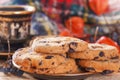 Oatmeal cookies on a wooden background with a cup of coffee and forest berries on the background of a warm scarf