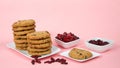 Oatmeal cranberry cookies on a plate with bowls of cranberries and craisins