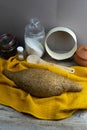 Oatmeal diet bread on a yellow towel in the background is satiated for flour, a jar of flour, spices and a spoon