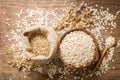 Oatmeal flakes, grains and ears of oat on wooden table