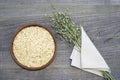 Oatmeal flakesl in a ceramic bowl on a rustic wooden table background and green ears of oats in a white linen napkin