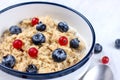 Oatmeal with fresh blueberries and red currant berries. Diet food - oatmeal porridge in a plate with a spoon Royalty Free Stock Photo