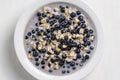 Oatmeal with fresh blueberry, almond milk and honey for breakfast in plate on wooden background. Rustic style. Top view Royalty Free Stock Photo