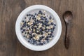 Oatmeal with fresh blueberry, almond milk and honey for breakfast in plate on wooden background. Rustic style. Top view Royalty Free Stock Photo