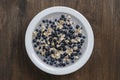 Oatmeal with fresh blueberry, almond milk and honey for breakfast in plate on wooden background. Rustic style. Top view Royalty Free Stock Photo