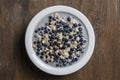 Oatmeal with fresh blueberry, almond milk and honey for breakfast in plate on wooden background. Rustic style. Top view Royalty Free Stock Photo