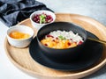 Oatmeal with fresh tangerine slices and pomegranate seeds, ground almonds and mint in a black bowl on wood round tray Royalty Free Stock Photo