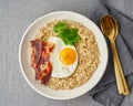 Oatmeal, fried egg and fried bacon. Hearty fat high-calorie breakfast, source of energy