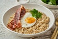 Oatmeal, fried egg, fried bacon. Hearty fat high-calorie breakfast. Balance of proteins, fats, carbohydrates, side view Royalty Free Stock Photo