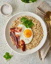 Oatmeal, fried egg, fried bacon. Intuitive conscious food, vertical Royalty Free Stock Photo