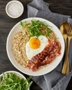 Oatmeal, fried egg, fried bacon. Balance of proteins, fats, carbohydrates. Balanced food. Vertical Royalty Free Stock Photo