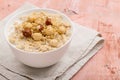 Oatmeal with hazelnut and honey on pink background