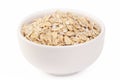 Oatmeal healthy uncooked dried flakes for muesli and breakfast porridge in white ceramic plate on light background macro