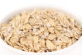 Oatmeal healthy uncooked dried flakes for muesli and breakfast porridge in white ceramic plate macro